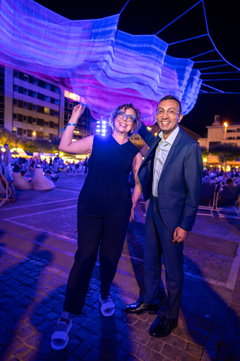 Janet Echelman suspends 103 kilometers of fiber over a Frankfurt plaza, lit by 24 fixtures mounted on its own support pylons