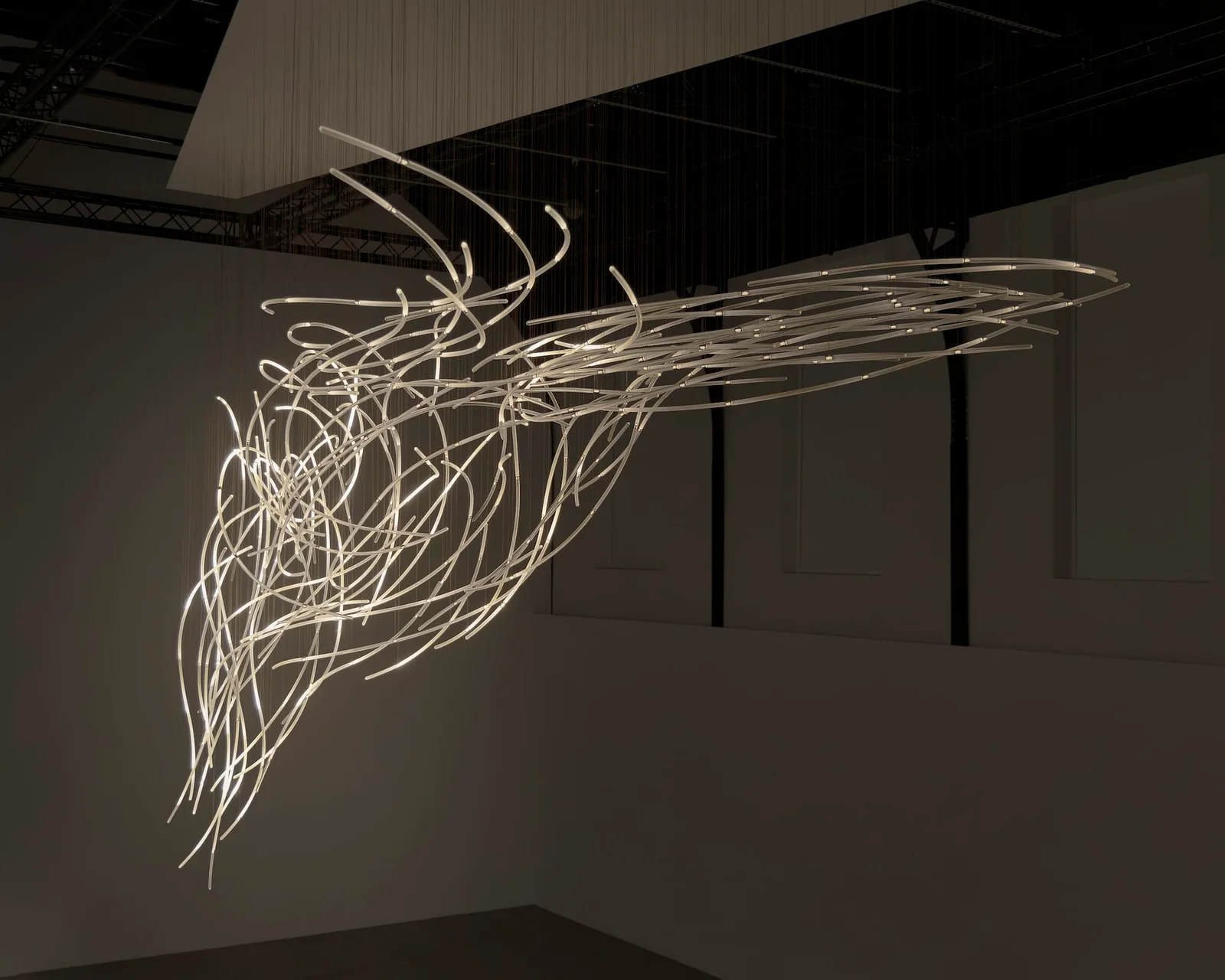 Hundreds of glass rods hold one moment of wind, and light moves through them as you walk