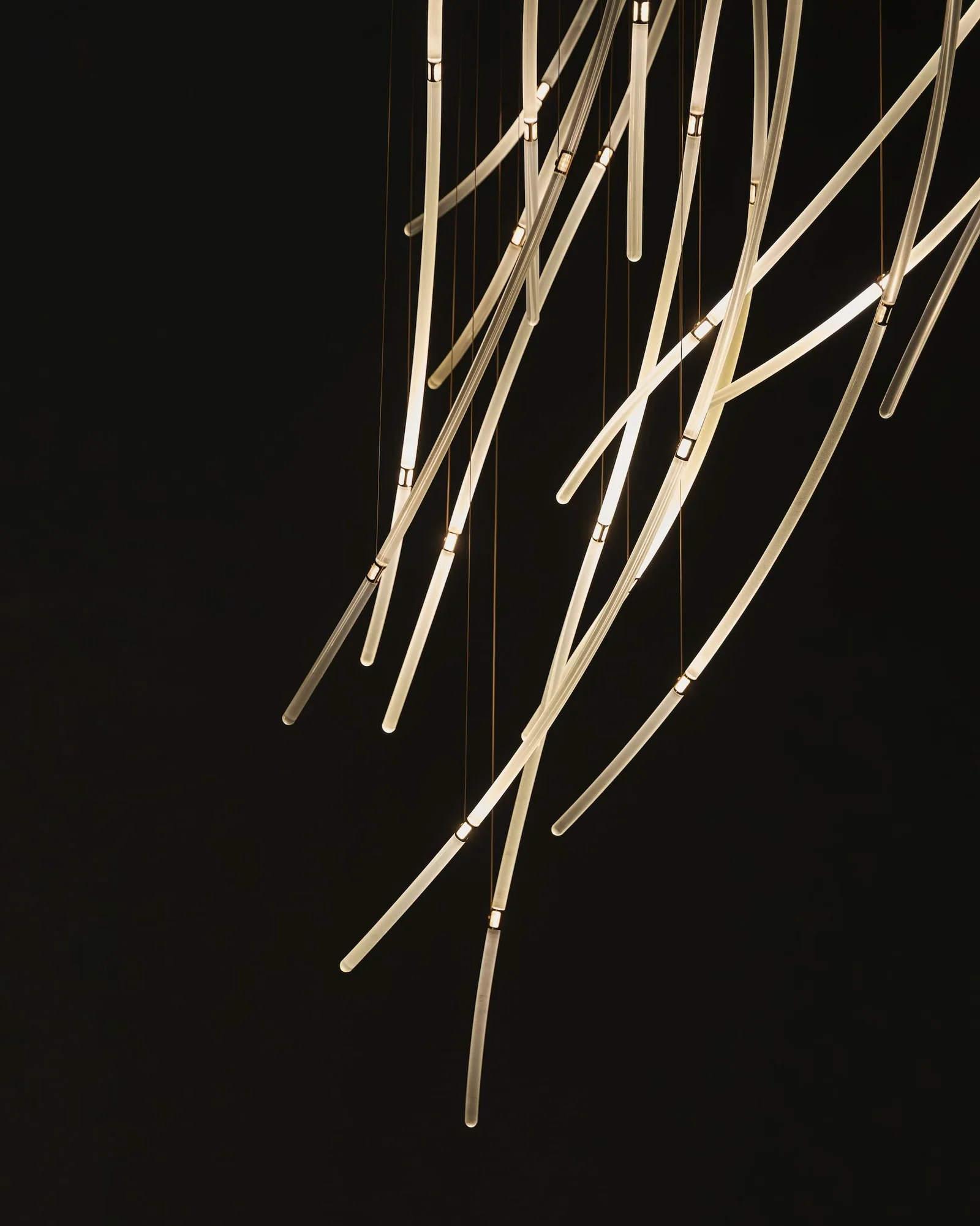 Hundreds of glass rods hold one moment of wind, and light moves through them as you walk